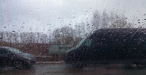 Raindrops on the window pane. Rainy city background