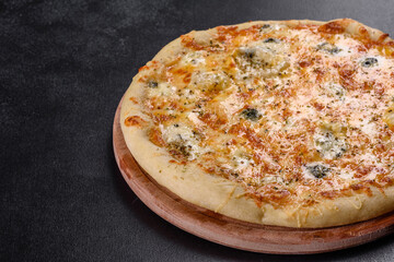 Tasty fresh oven pizza with tomatoes, cheese and mushrooms on a dark concrete background