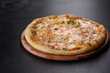 Tasty fresh oven pizza with tomatoes, cheese and mushrooms on a dark concrete background