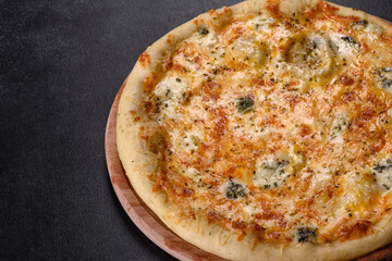 Tasty fresh oven pizza with tomatoes, cheese and mushrooms on a dark concrete background