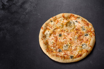 Tasty fresh oven pizza with tomatoes, cheese and mushrooms on a dark concrete background