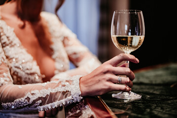 bride drinking wine on her wedding day white dress