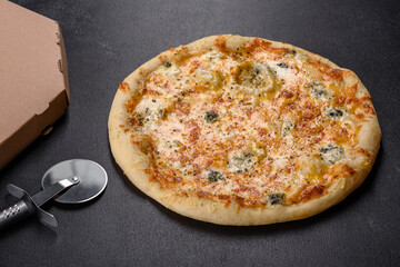 Tasty fresh oven pizza with tomatoes, cheese and mushrooms on a dark concrete background