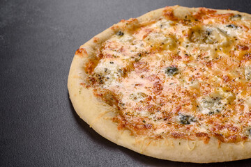Tasty fresh oven pizza with tomatoes, cheese and mushrooms on a dark concrete background
