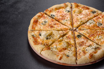 Tasty fresh oven pizza with tomatoes, cheese and mushrooms on a dark concrete background