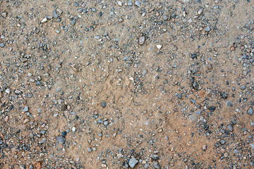 close-up of pathway with sand and many small rocks and stones around. top view