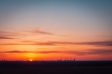 Fototapeta na wymiar Sunset over an industrial oil refinery (enterprise).