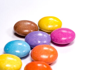 Colorful dragees, close-up on a white background. Chocolate candies in a colored shell, glaze.