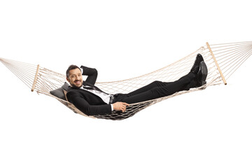 Happy young businessman lying on a hammock swing