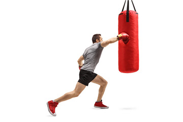 Strong man exercising and punching a boxing bag