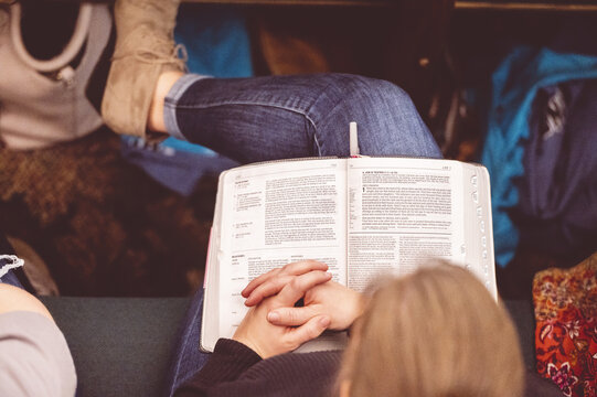 Overhead Shot Of A Female Reading The Bible During A Church Gathering