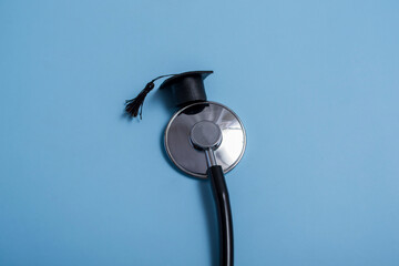 Stethoscope and graduate hat, on a blue background, top view, medical background graduate achievement, background