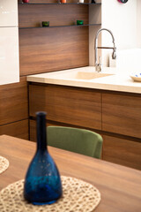 Modern kitchen, wooden walnut dining table and green chairs