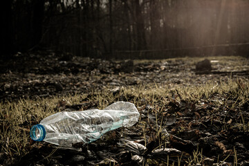 Environmental concept. Forest with trash, plastic rubbish. garbage waste in environment woodland. Ecological problem with Empty used dirty plastic bottles.