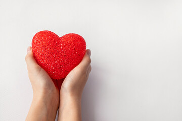 The girl is holding a red heart, isolated on a white background.