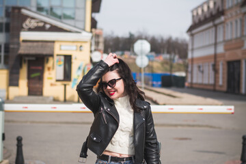 Fototapeta premium Beautiful young girl student hipster walks along the street of her city