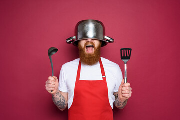 Man chef is ready to fight in the kitchen. burgundies background