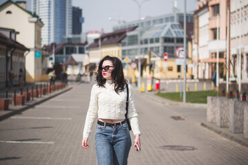 Fototapeta premium Beautiful young girl student hipster walks along the street of her city