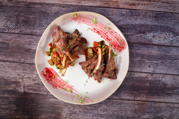 Spicy hot fried spare ribs on a plate against the background of a wooden table.