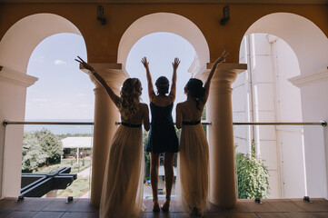 three bridesmaids having fun on the balcony back view