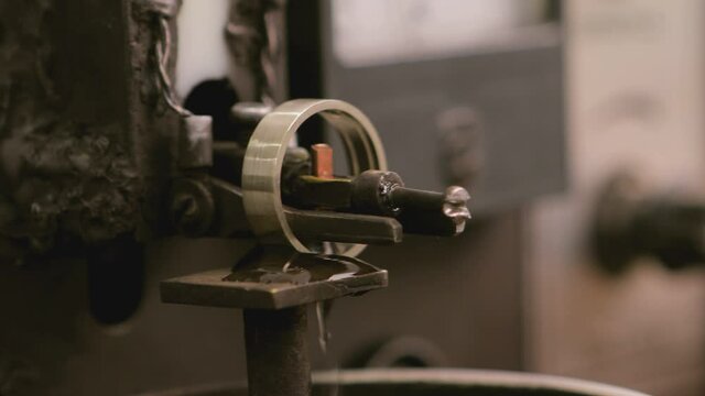 Close up shot of special machine for hallmarking jewelry , golden or silver ring . Process of probing , marking , creating precious ring . Jewellery industrial factory . 
