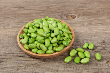 raw green soybean in plate on wooden background. fresh beans.