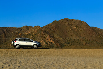 Fototapeta na wymiar Suv car parked in Mountainous landscape in the desert