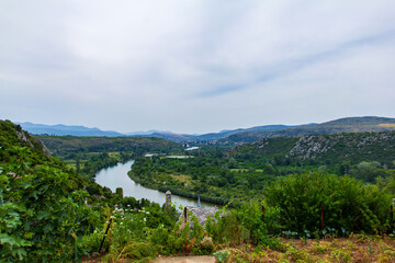 Obraz premium View of old village in Poictelj. Bosnia-Herzegovina during summer sunny cloudy day with mountains and river in the back.