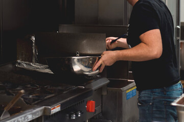 Restaurant employee using frier in a kitchen
