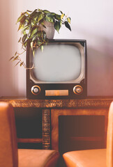 Old vintage retro TV in a living room with chairs