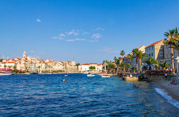 Naklejka premium View of Korcula shore during sunny summer day, beautiful small city with red roofs buldings and cristal water.