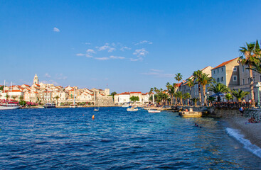 Fototapeta na wymiar View of Korcula shore during sunny summer day, beautiful small city with red roofs buldings and cristal water.