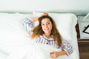 Portrait of a woman in pajamas waking up in her bedroom