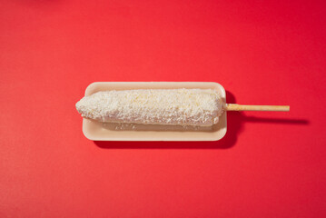 elote cocido preparado con salsa, mayonesa, queso y papas, snack mexicano