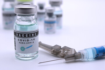 Vaccine vials next to a syringe