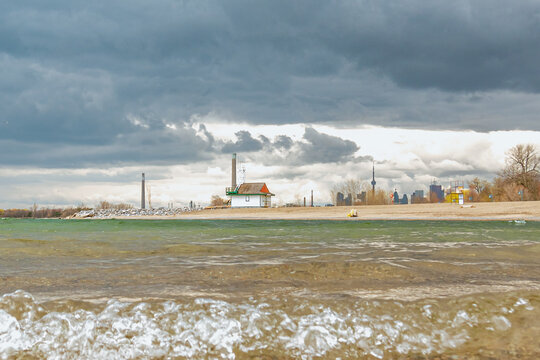 
The Leuty Lifeguard Station seen from Kew Beach with some of  the downtown skyline and the CN Tower in the background under dramatic spring clouds. (wide)