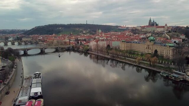 View from drone to motor boat sailing on Vltava river at cloudy day.