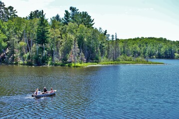 family in a rowboat in the middle of a lake upper peninsula michigan - obrazy, fototapety, plakaty