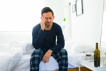 Guy in pajamas suffering from a headache