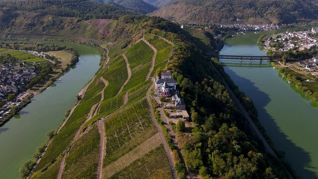 Aerial drone shot of castle on the Moselle River bend in Bremm, Germany.