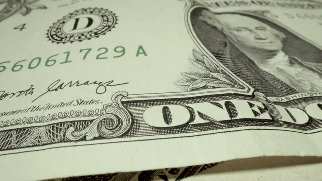 Tight macro slider of text printed on paper fiat money the official minted one dollar bill with dead president George Washington 's portrait on the front face of the official United States currency