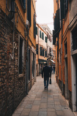 The italian street with beautiful buildings and people around. Film effect and author processing of photo.