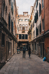 Fototapeta na wymiar The italian street with beautiful buildings and people around. Film effect and author processing of photo.