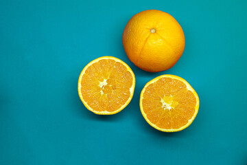 Oranges cut in halves on blue background, set of oranges flat lay