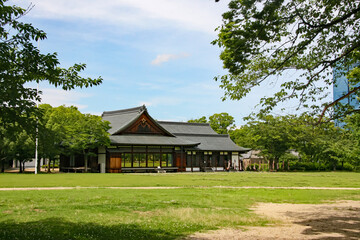 Fototapeta na wymiar 大阪城西の丸庭園の緑の芝生と木造の和風建築