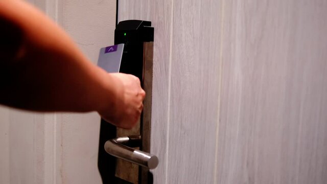 Electronic Digital smart door automatic lock security system using unique key card code to unlock. Smart home safety secure access modern living technology, man opening door using card to unlock.