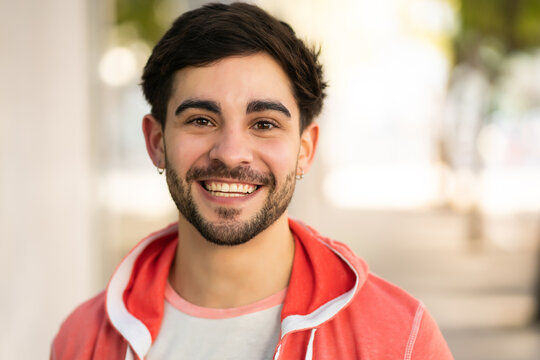 Close-up of young man smiling outdoors. - Powered by Adobe