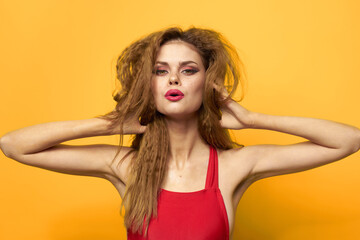 Pretty woman wavy hair red tank top fashion lifestyle cosmetics yellow background