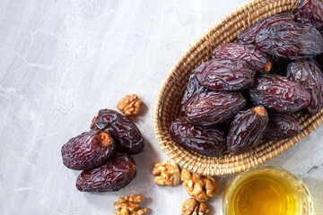 Med jool dates friuts in a basket with walnuts and tea as an element. Top View.