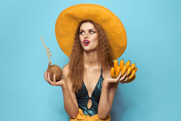 Fototapeta na wymiar Woman in swimsuit hat exotic fruits summer fun blue background